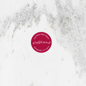 Circle address sticker in red with modern script font.