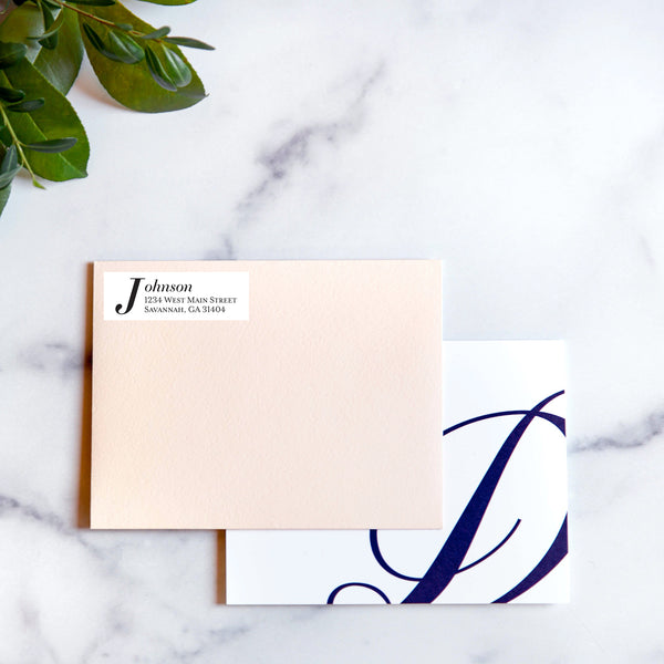 blush envelope with white classic serif address sticker and monogram notecard