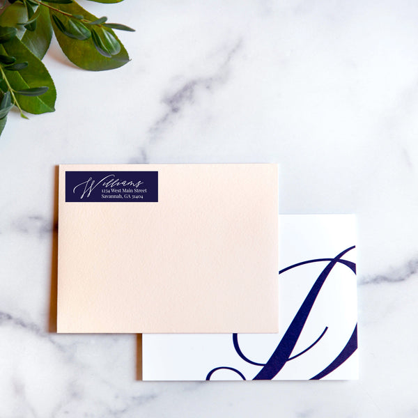 blush envelope with navy script address sticker and monogram notecard