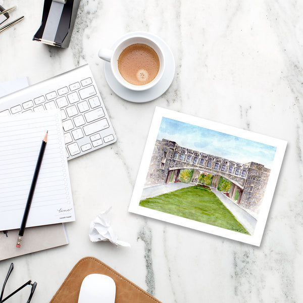 Art print of Virginia Tech Torgersen Bridge notecard on marble desk with latte, keyboard, and stylish office accessories.